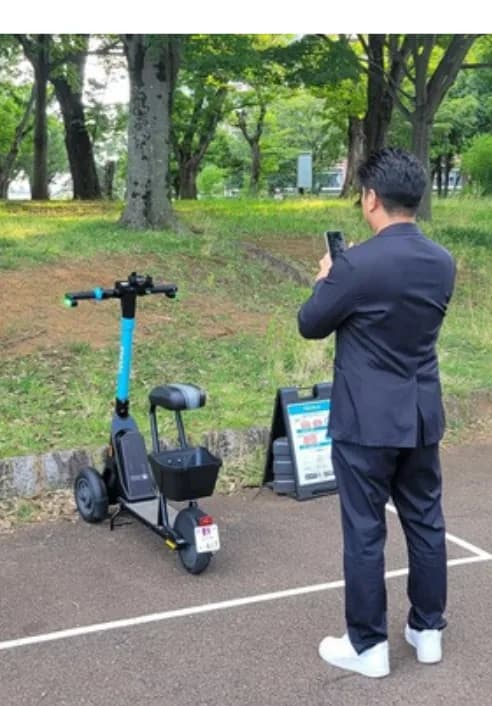ポートに停めた車両を、スマートフォンで撮影しているところ。