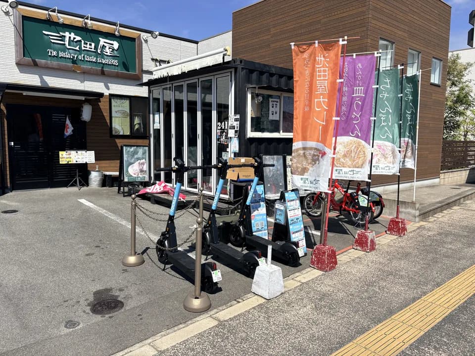 池田屋のポート。店の看板とのぼり旗の前に TOCKLE が並び、右手には貸自転車も停まっている