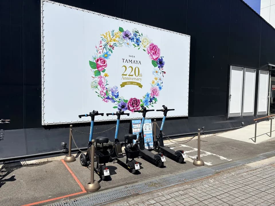 佐賀玉屋 東別館のポート。花輪を描いた大きな白い掲示幕の前に、TOCKLE が4台並んでいる
