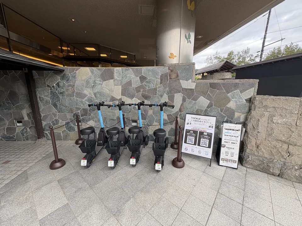 定山渓第一寶亭留 翠山亭のポート。玄関脇の石張りの壁の前に TOCKLE が4台並び、右手に案内看板が置かれている